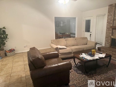 A living room with a brown leather chair and a white couch.