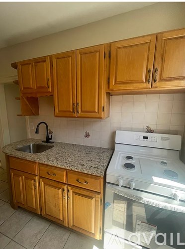 A kitchen with wooden cabinets and a white dishwasher.