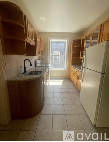 A kitchen with wooden cabinets and a white refrigerator.