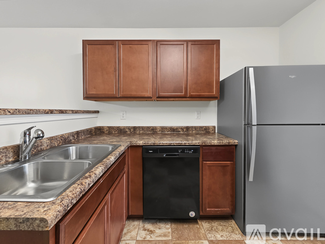 A black stove top oven in a kitchen with brown cabinets.