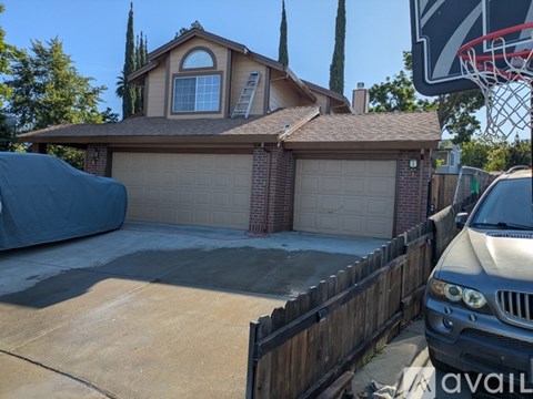 A house with a basketball hoop in the backyard.
