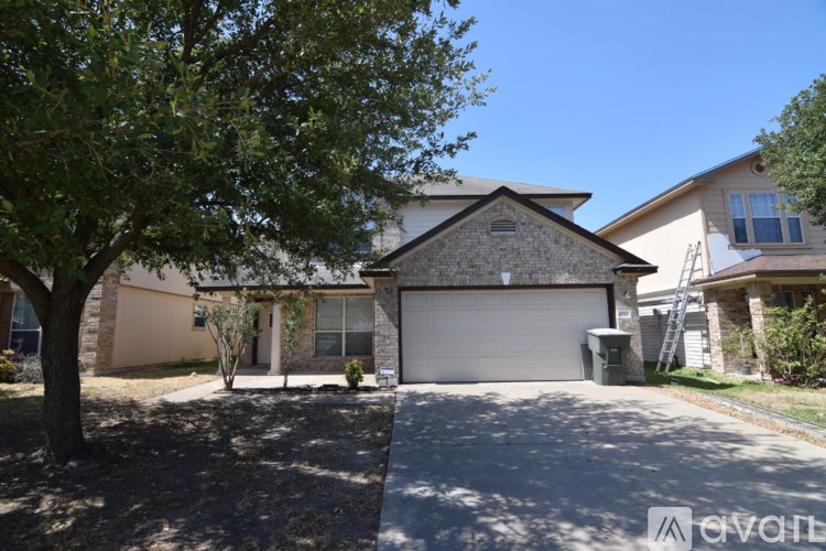 A house with a garage and a tree in front.