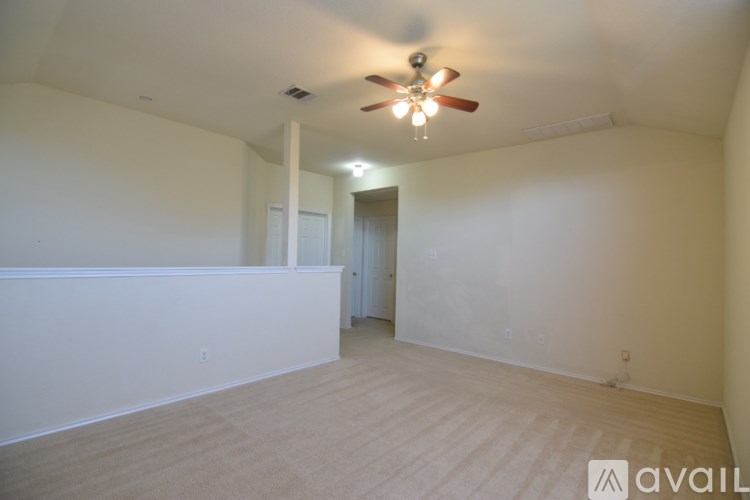 A room with a ceiling fan and a door.