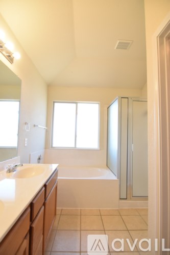A bathroom with a tub, sink, and mirror.
