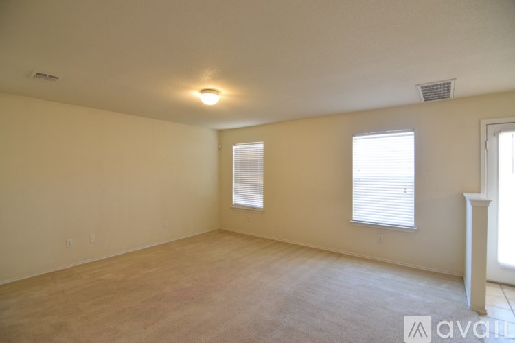 A spacious room with a window and a carpeted floor.