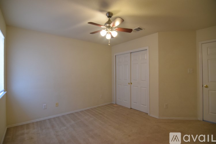 A room with a ceiling fan and two doors.