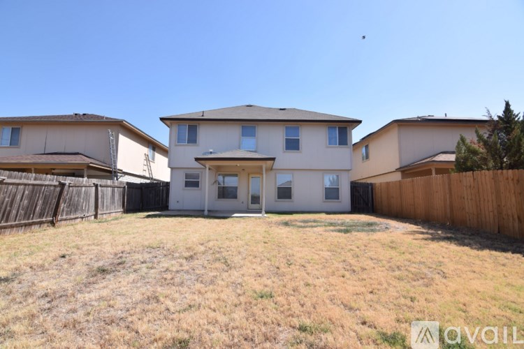 A house with a fence and a field in front of it.