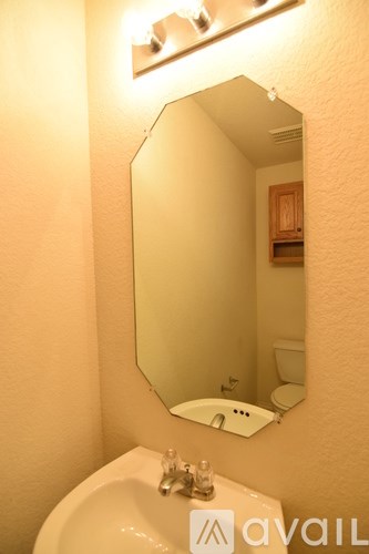 A bathroom with a sink, mirror and toilet.