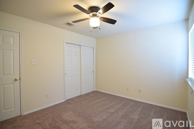 A room with a ceiling fan and two doors.