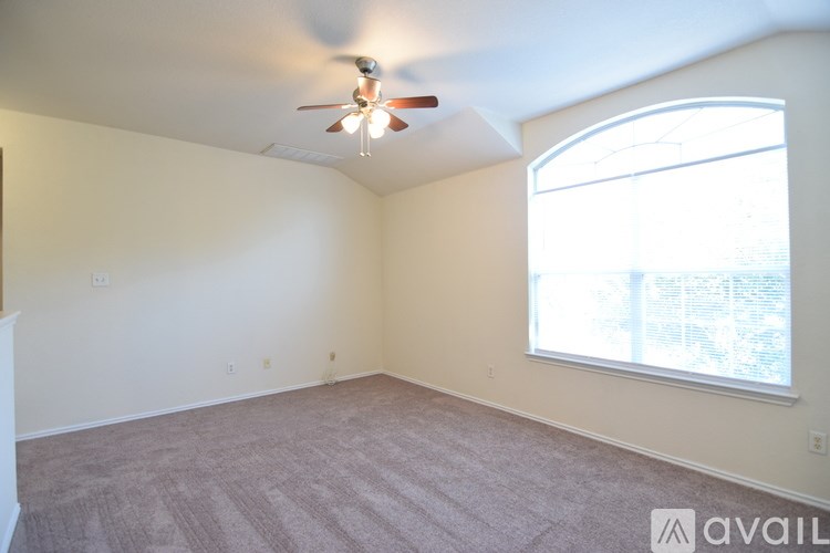 A room with a ceiling fan and a window.