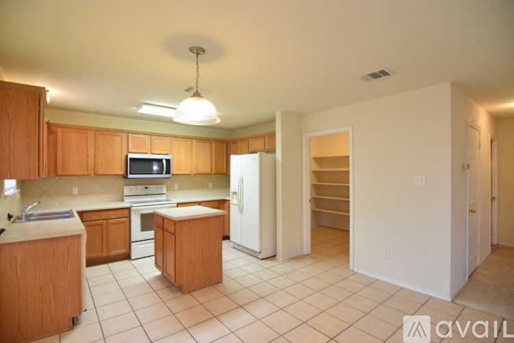 A kitchen with wooden cabinets and a white refrigerator.
