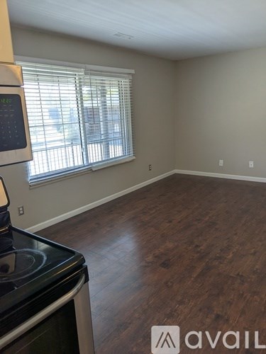 A kitchen with a stove top oven and a window with blinds.