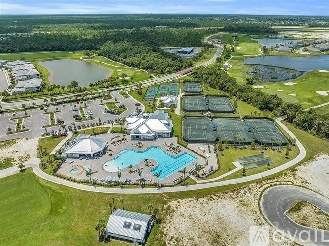 A bird's eye view of a resort with a swimming pool and tennis courts.