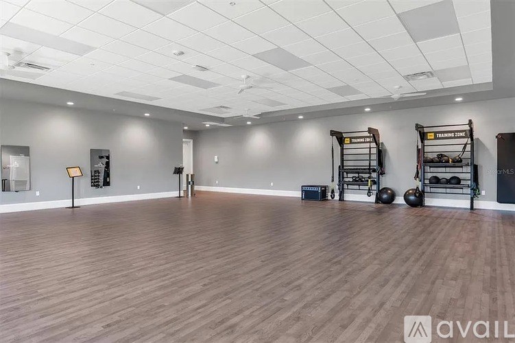 A gym with wooden floors and various exercise equipment.