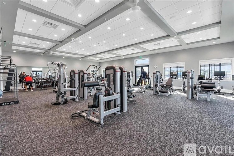 A gym with a variety of equipment including treadmills, weights, and exercise machines.