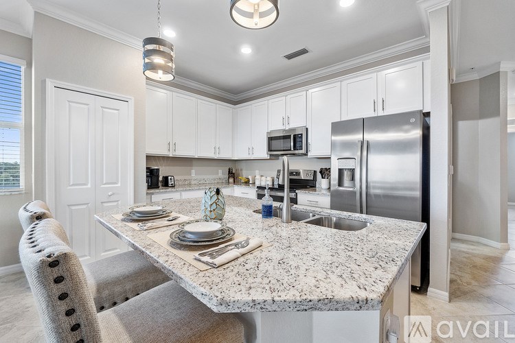 A kitchen with a granite countertop and stainless steel appliances.