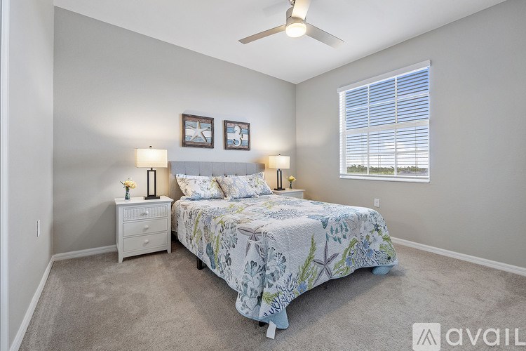 A bedroom with a bed, two nightstands, and a window.