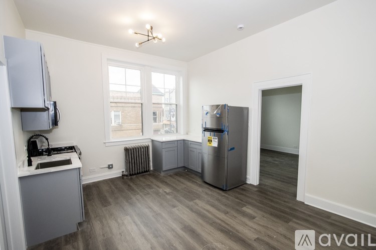 A kitchen with a refrigerator, sink, and a window.