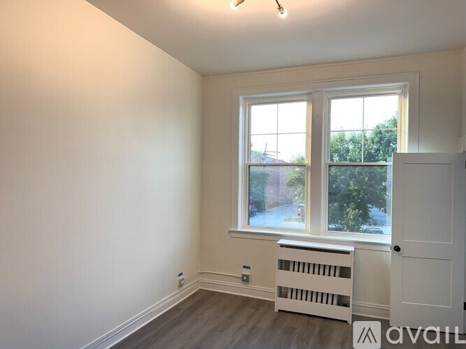 A room with a window and a radiator on the floor.