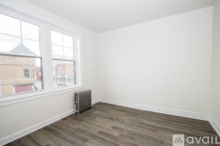A room with a window and a radiator on the floor.