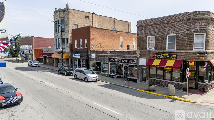 A street view of a town with a car dealership on the right.