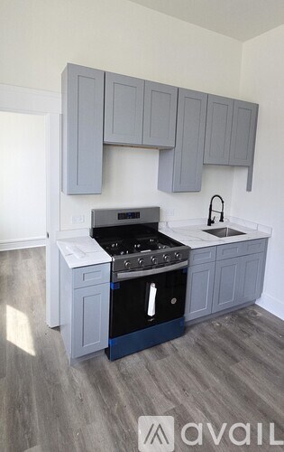 A kitchen with a black stove top oven and a white dishwasher under a cabinet.