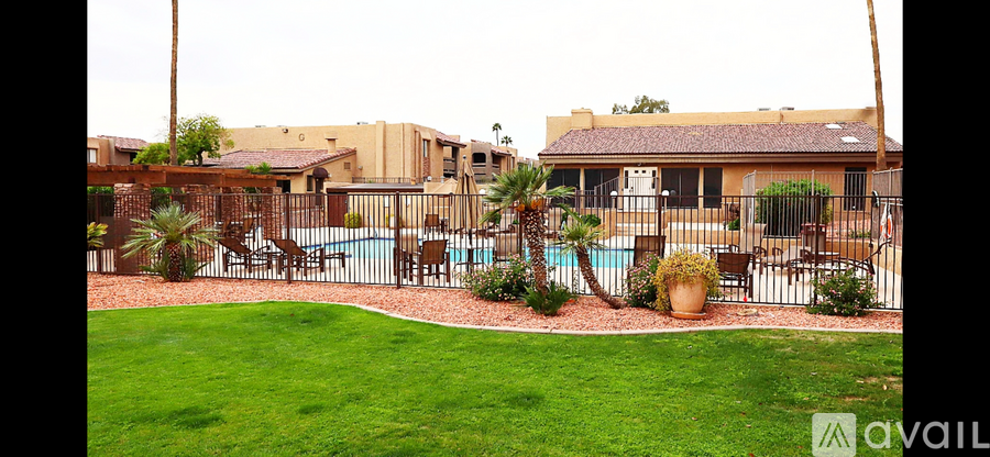 A backyard with a pool and patio furniture.