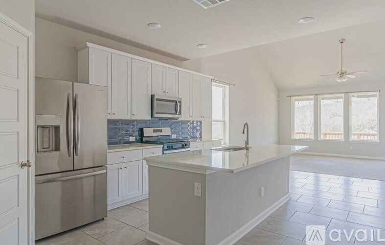 A kitchen with white cabinets and a stainless steel refrigerator.