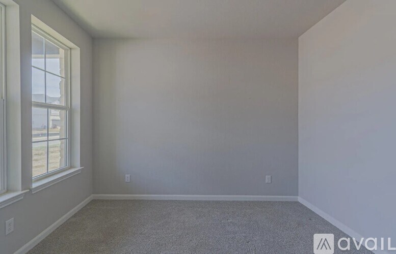 A room with a window and carpeted floor.