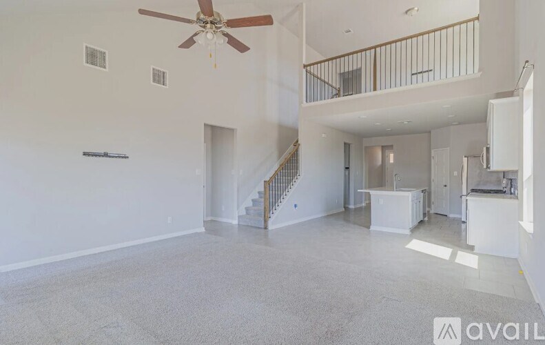 A spacious living room with a staircase leading to the upper floor.