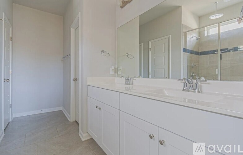 A bathroom with a large mirror and a sink.