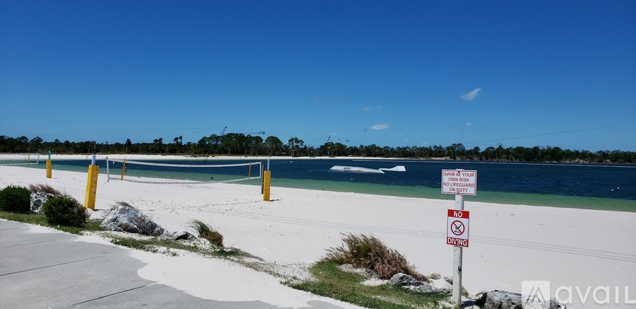 A sign on a post at the beach warns against swimming.