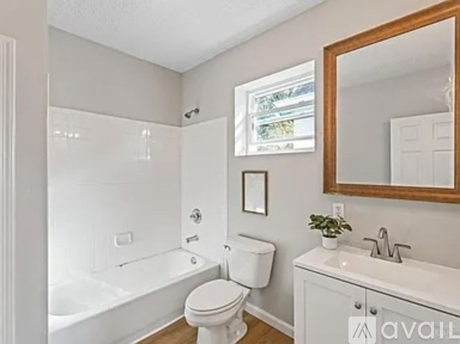 A white bathroom with a toilet, sink, and bathtub.