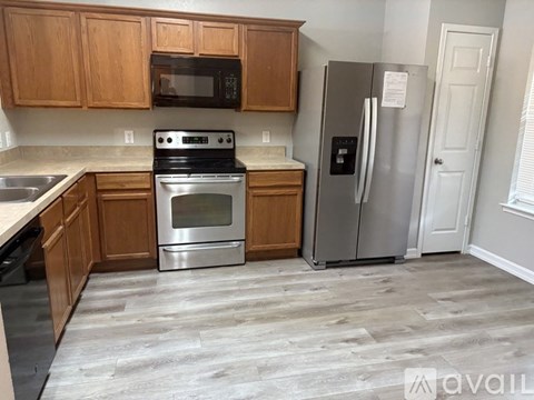 A kitchen with wooden cabinets and a stainless steel refrigerator.