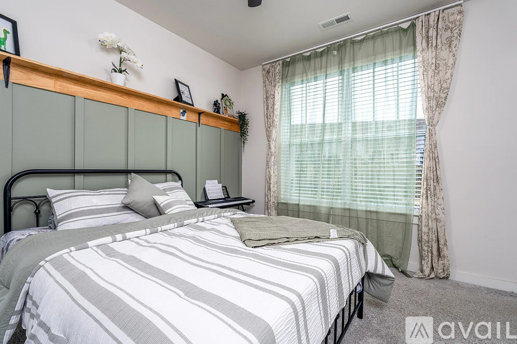 A bedroom with a large bed and a window with curtains.
