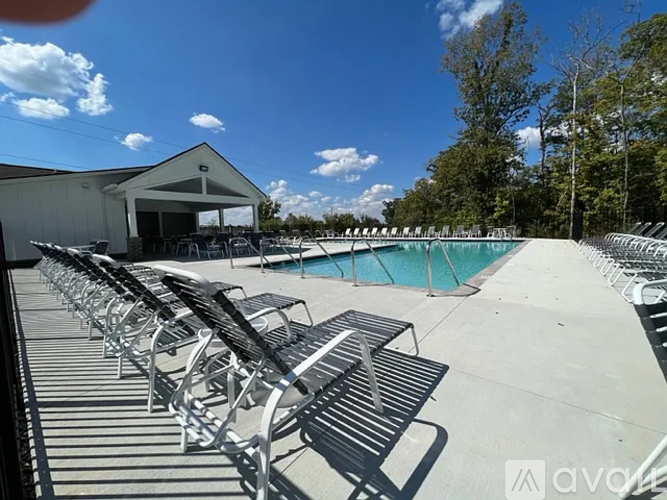 A poolside area with sun loungers and a building in the background.