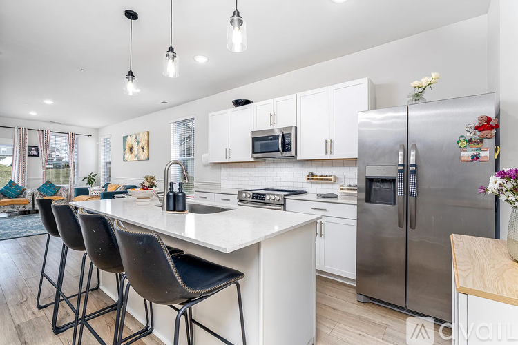 A modern kitchen with a white countertop and stainless steel appliances.