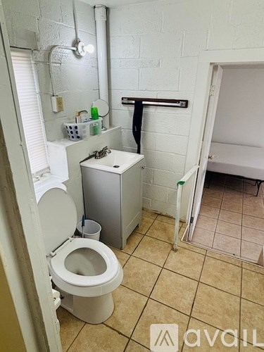 A bathroom with a toilet, sink, and a white cabinet.