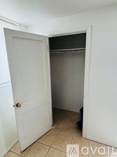 A white door is open to a small, empty room.