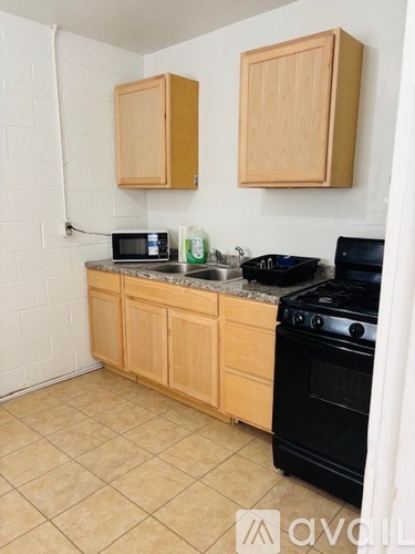 A kitchen with wooden cabinets and black appliances.