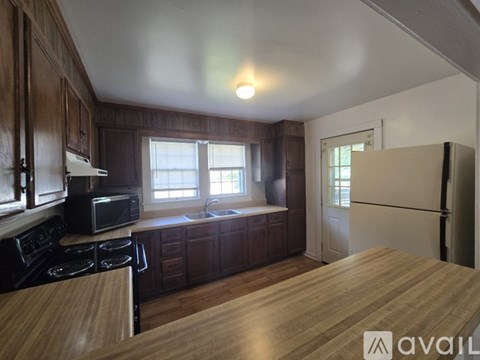 A kitchen with wooden cabinets and a black stove top oven.