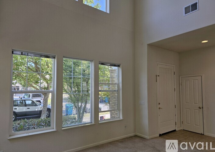 A kitchen area with a refrigerator, sink, and cabinets.