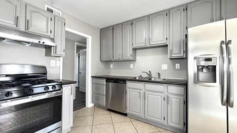 A kitchen with a stove top oven and a refrigerator.