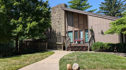 A house with a stone chimney and a wooden deck.