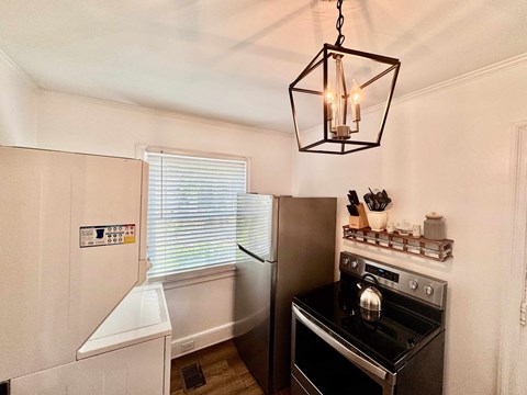 A kitchen with a stove top oven and a refrigerator.