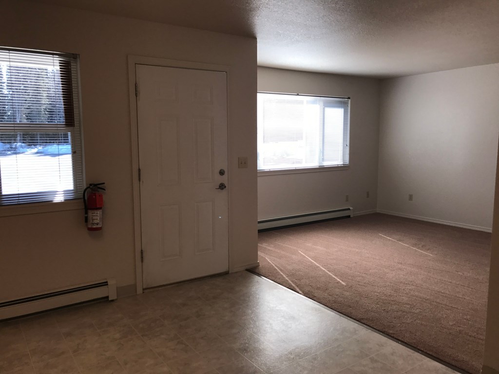 A room with a door, window, and fire extinguisher.