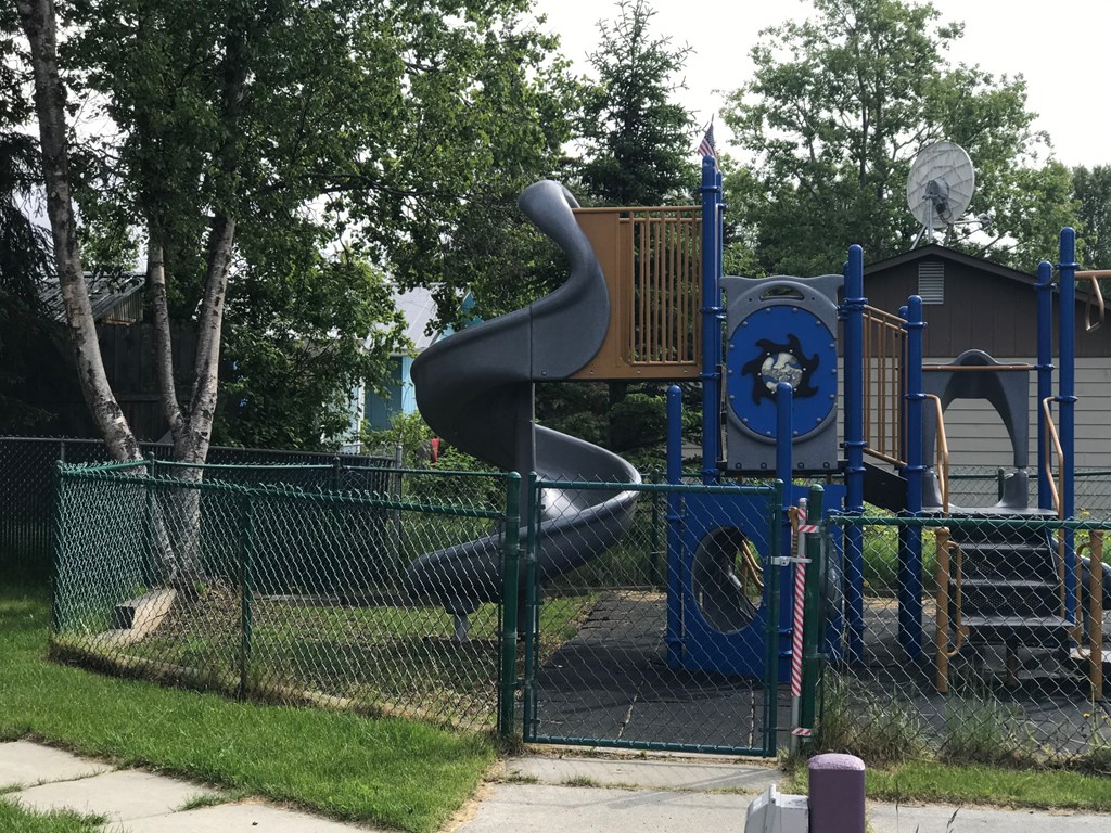 A playground with a blue and yellow slide.