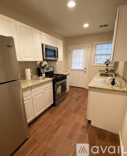 A kitchen with white cabinets and a refrigerator.
