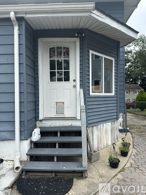 A small house with a white door and a small porch.