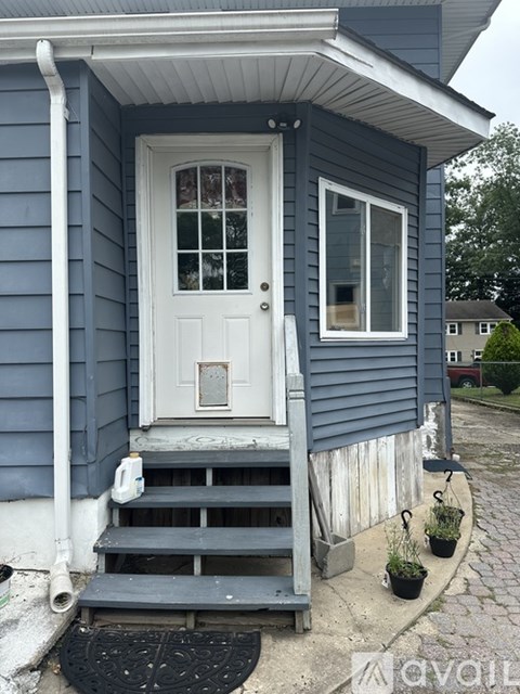 A small house with a white door and a small porch.